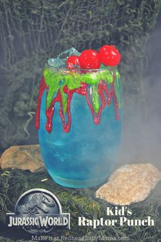 a blue drink with red cherries and green sprinkles on the rim