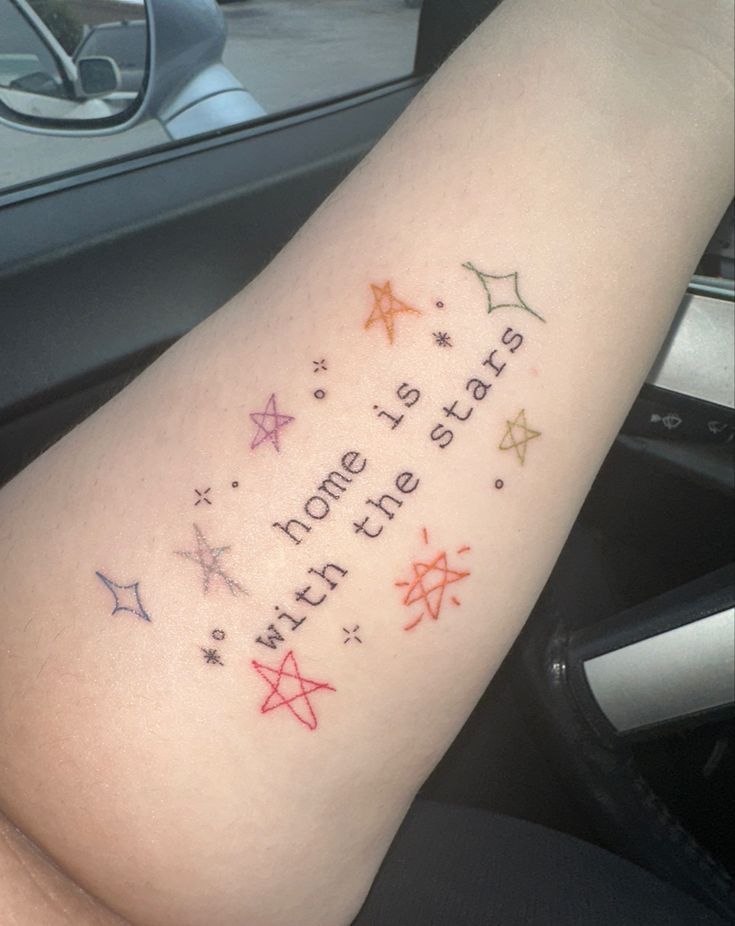 a woman's arm with stars and words on it