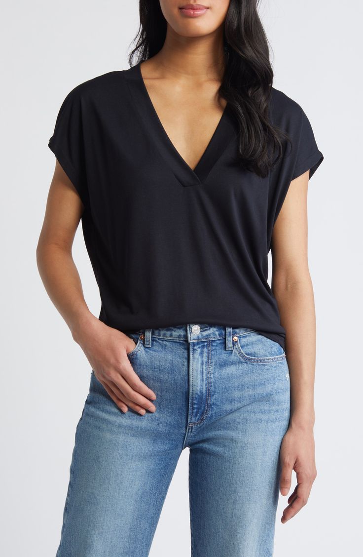 This nicely draped V-neck top is made from supersoft, fluid knit fabric with dropped shoulders to further the casual-chic look. 23 1/2" length V-neck Short sleeves 79% Tencel® modal, 21% polyester Tencel modal is a more-sustainably produced fiber made with closed-loop processing and is certified with the EU Ecolabel as having a low environmental impact throughout the entire lifecycle Machine wash, dry flat Made in Turkey Casual Soft Stretch Top For Work, V-neck T-shirt For Work, Flattering V-neck Top For Spring, Versatile Rayon Tops For Layering, Sleek V-neck Tops For Spring, Chic Rayon Tops For Layering, Casual Black Tops With Foldover Top, Chic Relaxed Fit Tops Made Of Modal, Chic Relaxed Fit Modal Tops