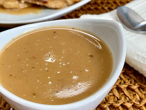 a bowl of soup sitting on top of a table next to a plate of food