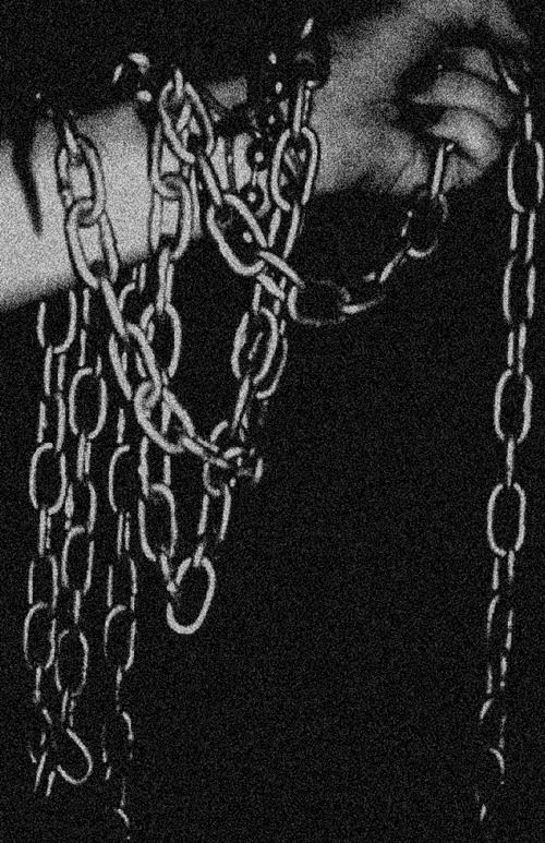 black and white photograph of hands holding chains