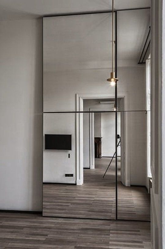 an empty room with mirrored walls and wooden floors