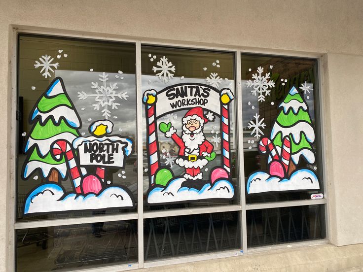 the window is decorated with santa's workshop signs and snowflakes on it