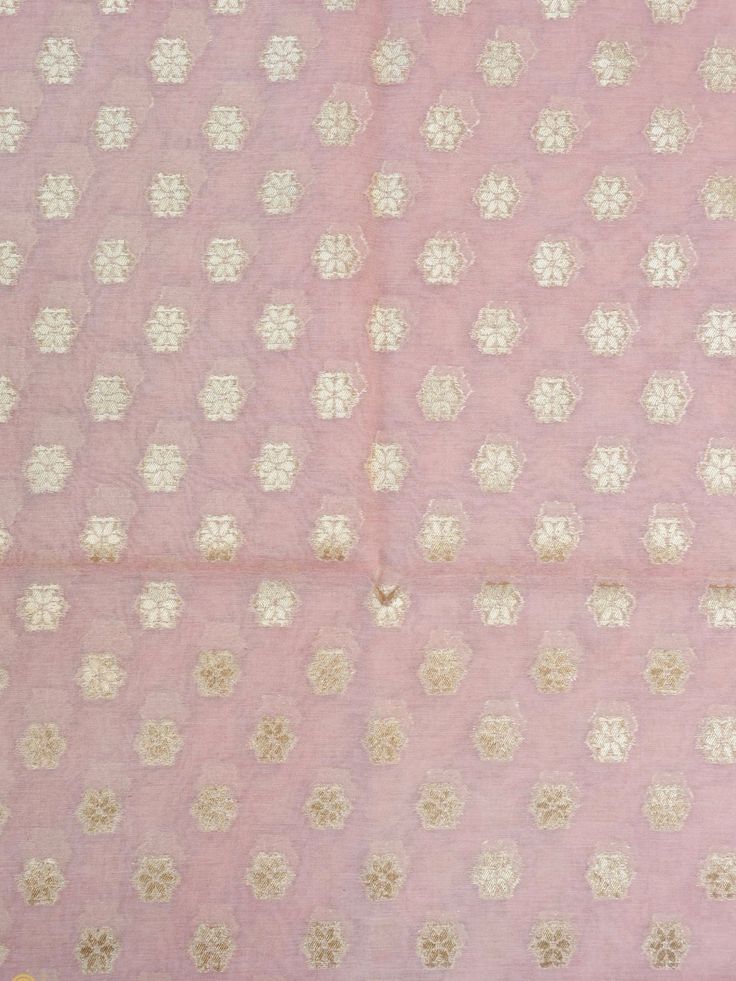 an old pink and gold cloth with small white flowers on it