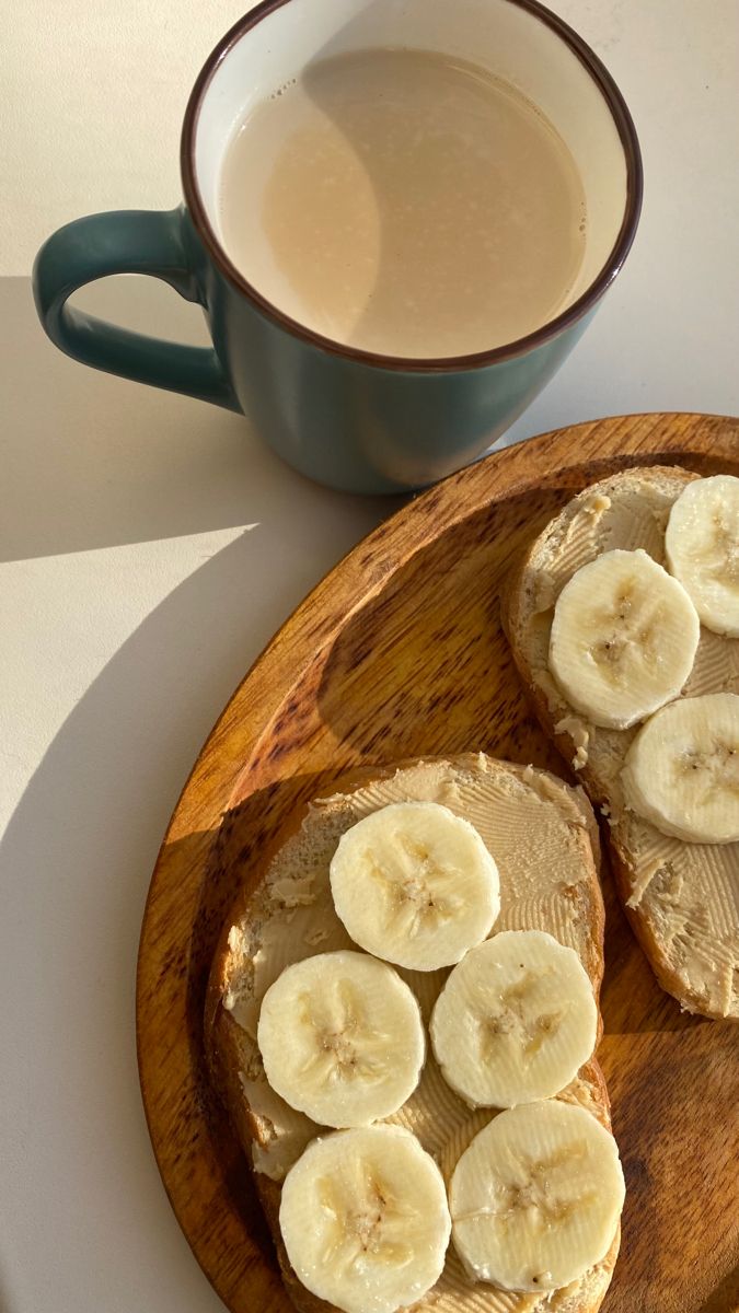 two slices of banana bread on a wooden plate next to a cup of coffee