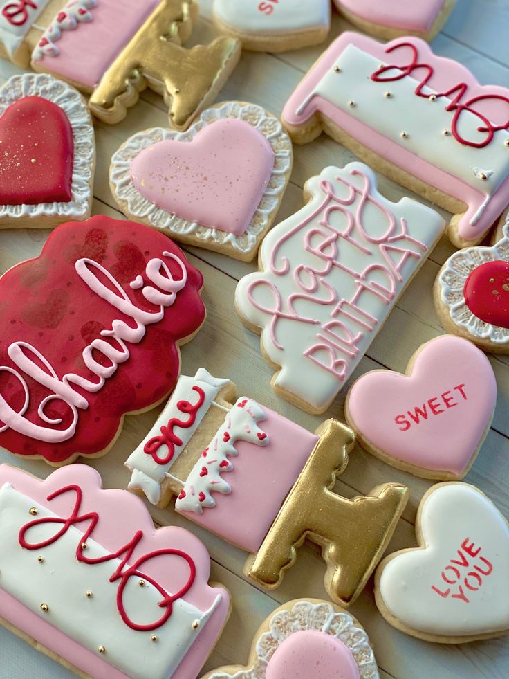 decorated cookies are arranged in the shape of heart, love and letter shapes on a table