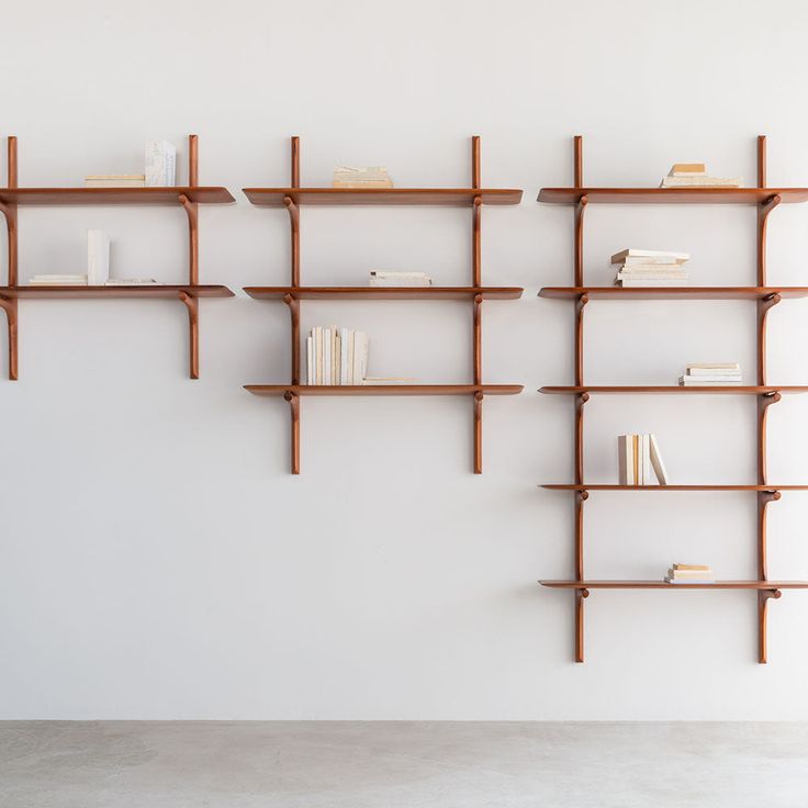 the bookshelves are made from wood and have different heights to fit in with each other