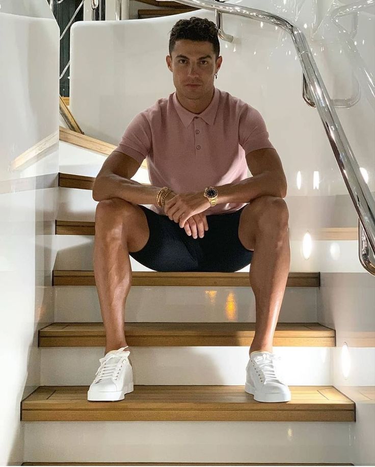 a man is sitting on the stairs in front of an escalator and looking at the camera