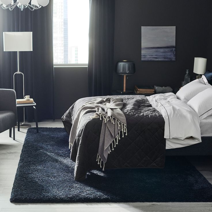 a black and white bedroom with a chandelier hanging from the ceiling, two chairs on either side