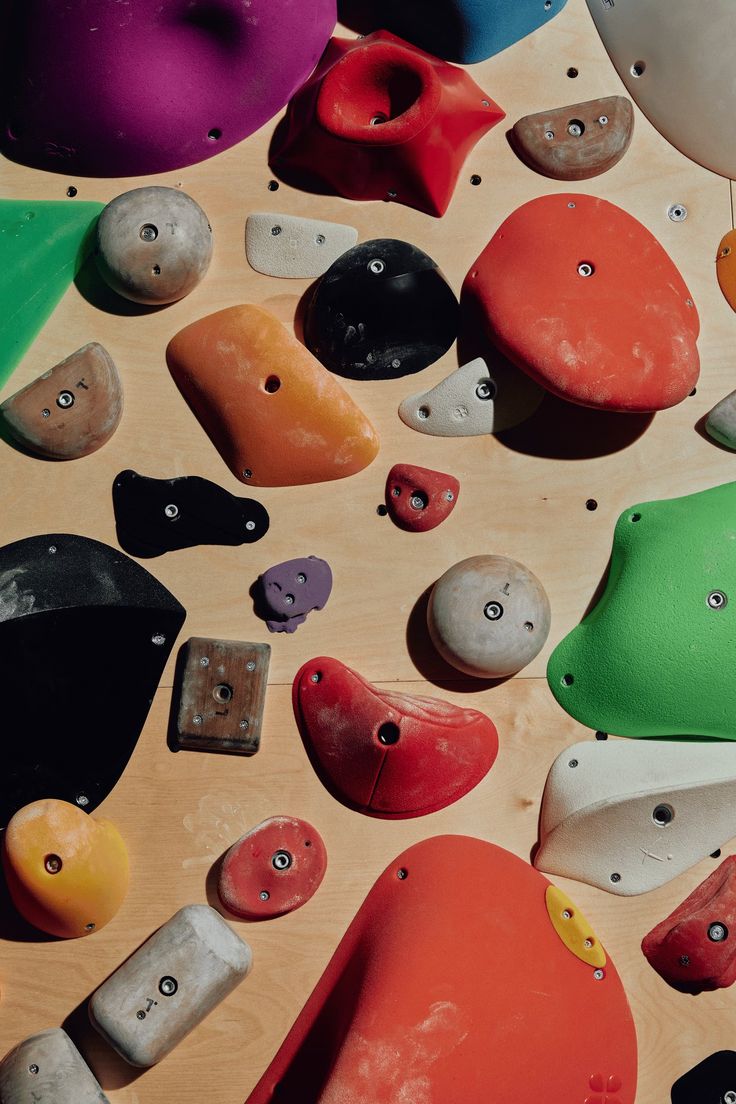 many different colored rocks are arranged on a wooden surface with holes in the middle to show them