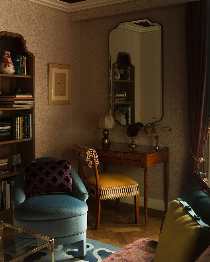 a living room filled with furniture and a large mirror on top of a wall next to a book shelf