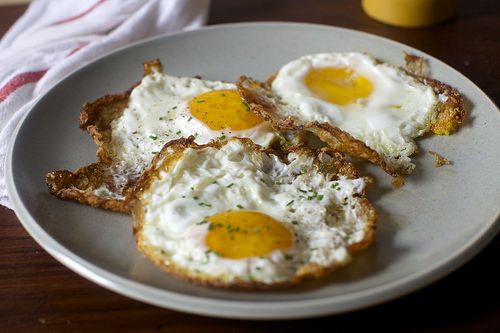 three fried eggs are on top of toasted bread