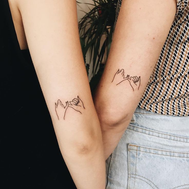 two people with matching tattoos on their arms