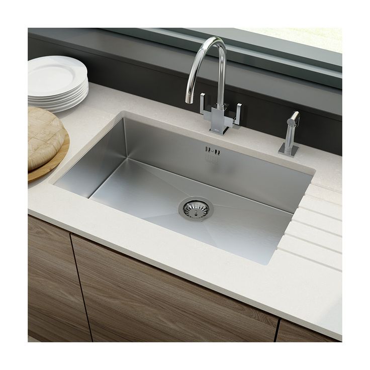 a stainless steel kitchen sink with faucet and soap dispenser on the counter