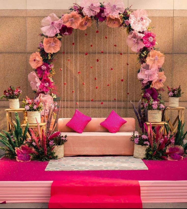 a pink and gold wedding stage decorated with flowers