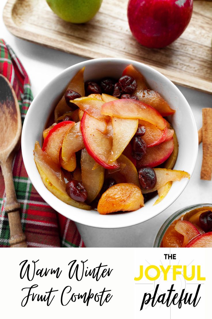 a bowl filled with fruit sitting on top of a wooden cutting board next to an apple