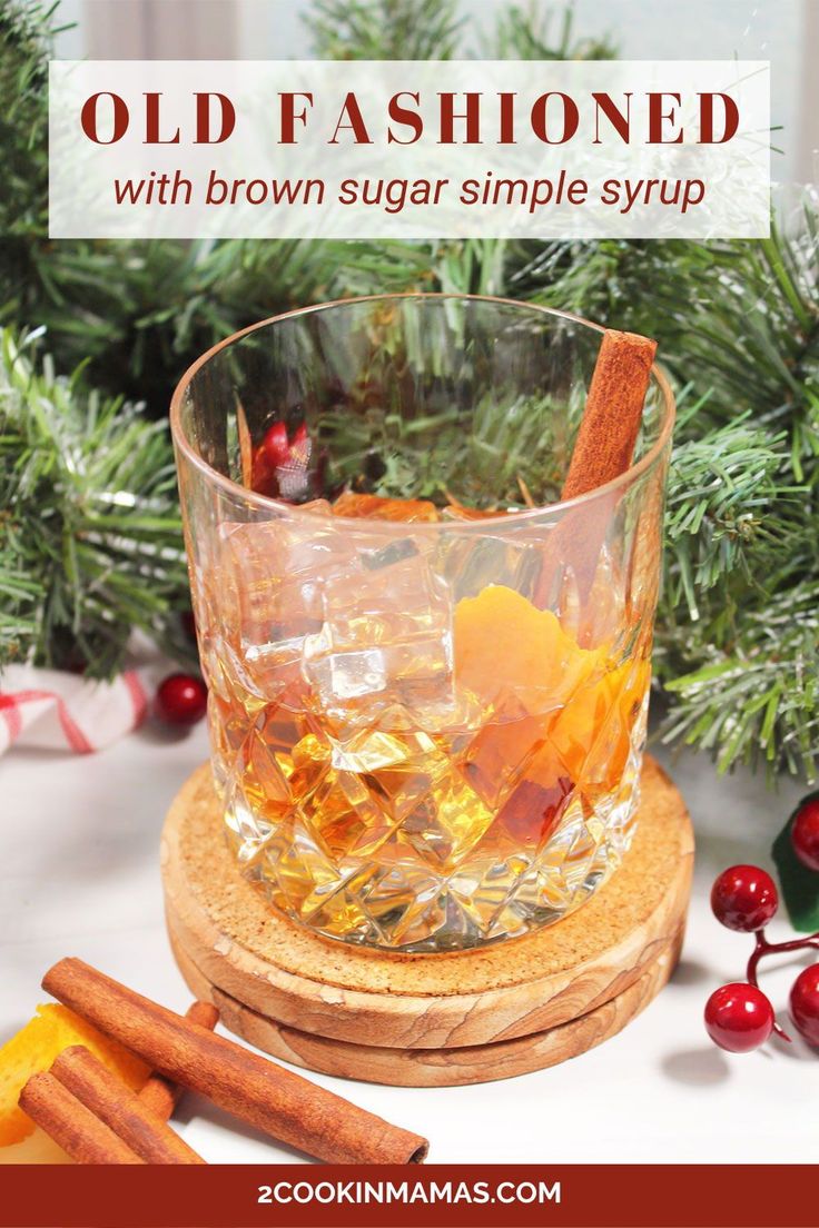 an old fashioned glass filled with orange slices and cinnamon sticks on top of a table