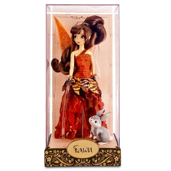 a doll in a box with an orange dress and rabbit figurine next to it