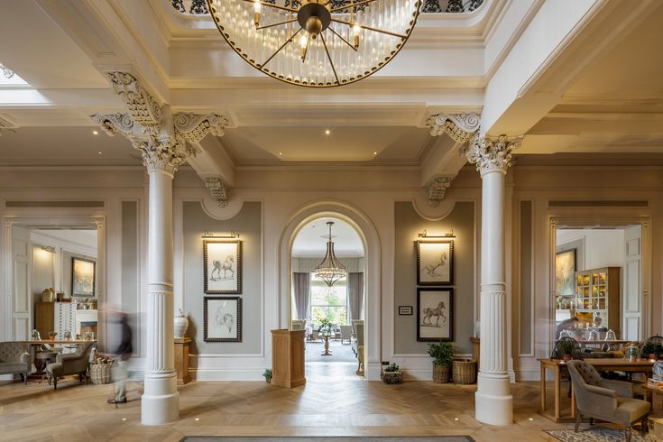 an elegant entry way with columns and chandelier