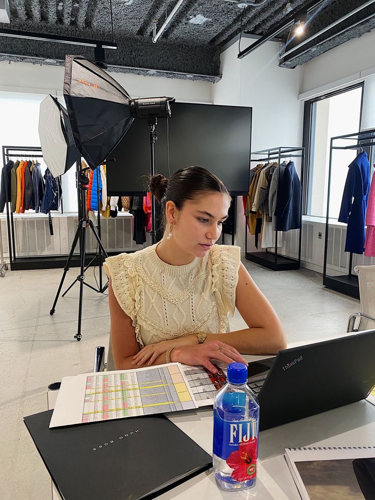 a woman sitting at a table using a laptop computer