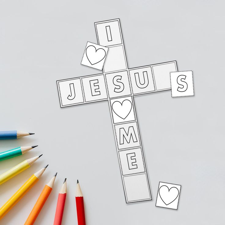 a cross with the word jesus on it surrounded by pencils and crayons