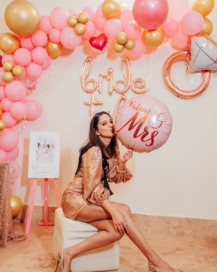 a woman is sitting on a stool with balloons in front of her and the words'bride to be '