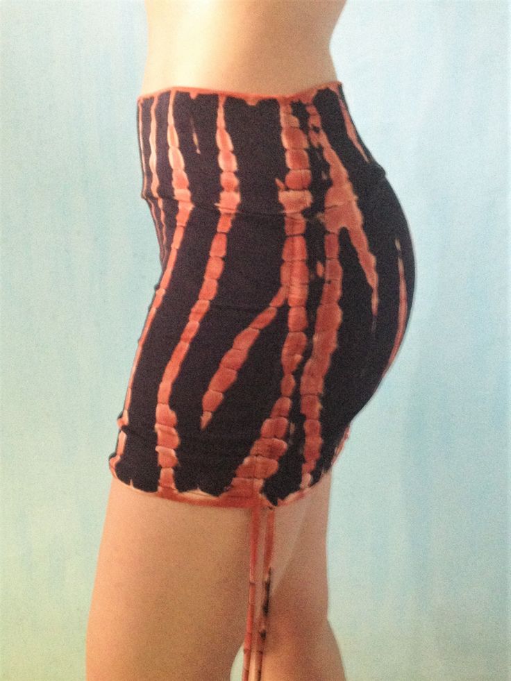 Our softest silkiest skirt, made from eco friendly rayon mixed with spandex, its super stretchy and form fits to your body's shape. Can be worn long, or cinch up the sides to make it shorter and tighter around your bum. Leave the top tall, or fold it over to customize fit. Fire tie dye is a gorgeous black with burnt orange streaks. Hand tied and dyed makes each one a unique wearable work of art. Will be similar to photos. Available in one size only, designed to be adjustable, fits most S/M. See Fitted Cotton Skirt With Built-in Shorts, Fitted High Waist Skirt With Elastic Waistband, High Waist Stretch Gathered Skirt, Fitted Cotton Mini Skirt With Built-in Shorts, Fitted Pencil Skirt Bottoms With Elastic Waistband, Fitted Tie-side Skirt For Spring, Fitted Ruched Cotton Skirt, Fitted Ruched Mini Skirt, Fitted Hip-length Mini Skirt For Summer