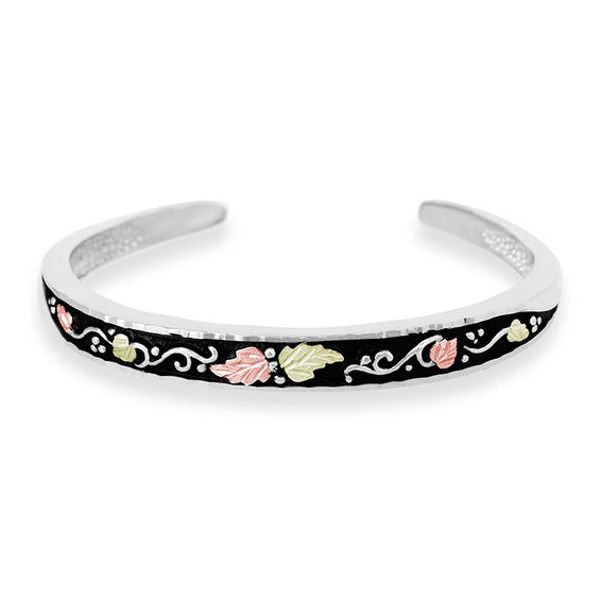 With elegant design, this cuff bracelet from Black Hills Gold is a great addition to any jewelry box. Fashioned in sterling silver, this pretty style features sculpted vine motif glistening with 12K green and rose gold leaves. Polished to a bright shine, this bracelet measures 6.25 inches in circumference and flexes to fit most wrists. Black Hills Gold jewelry is manufactured in the Black Hills of South Dakota and keeps the traditional style from the 1870's of grape leaves, grape clusters and vi Black Hills Gold Jewelry, Black Hills Gold, Gold Leaves, Jewelry Essentials, Black Hills, Childrens Jewelry, Gold Branding, Pretty Style, Grape Leaves