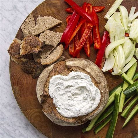 an assortment of vegetables and dip on a wooden platter