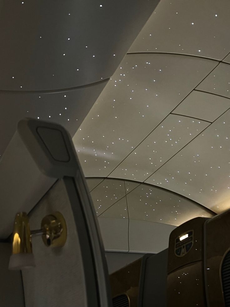 the interior of an airplane with stars on the ceiling and lights in the back ground