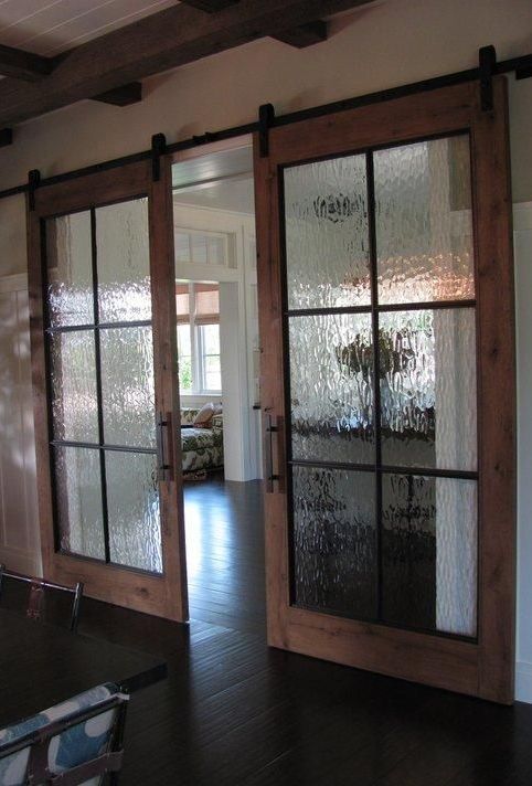 an empty room with glass doors and chairs