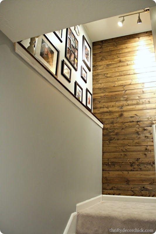 a stairway with pictures on the wall and carpeted steps leading up to an upstairs landing