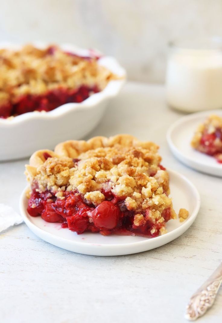 two white plates topped with pie on top of a table