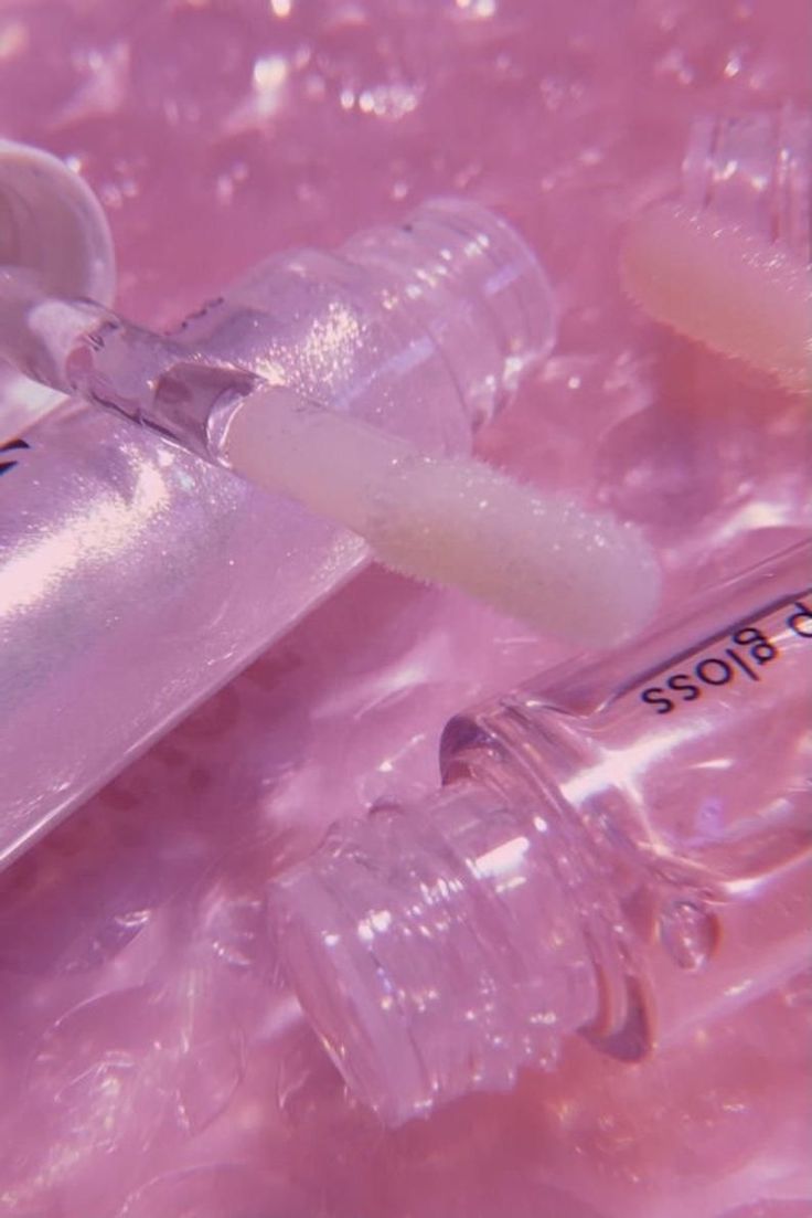 an injector is placed next to two empty plastic bottles on the ground with water droplets around it