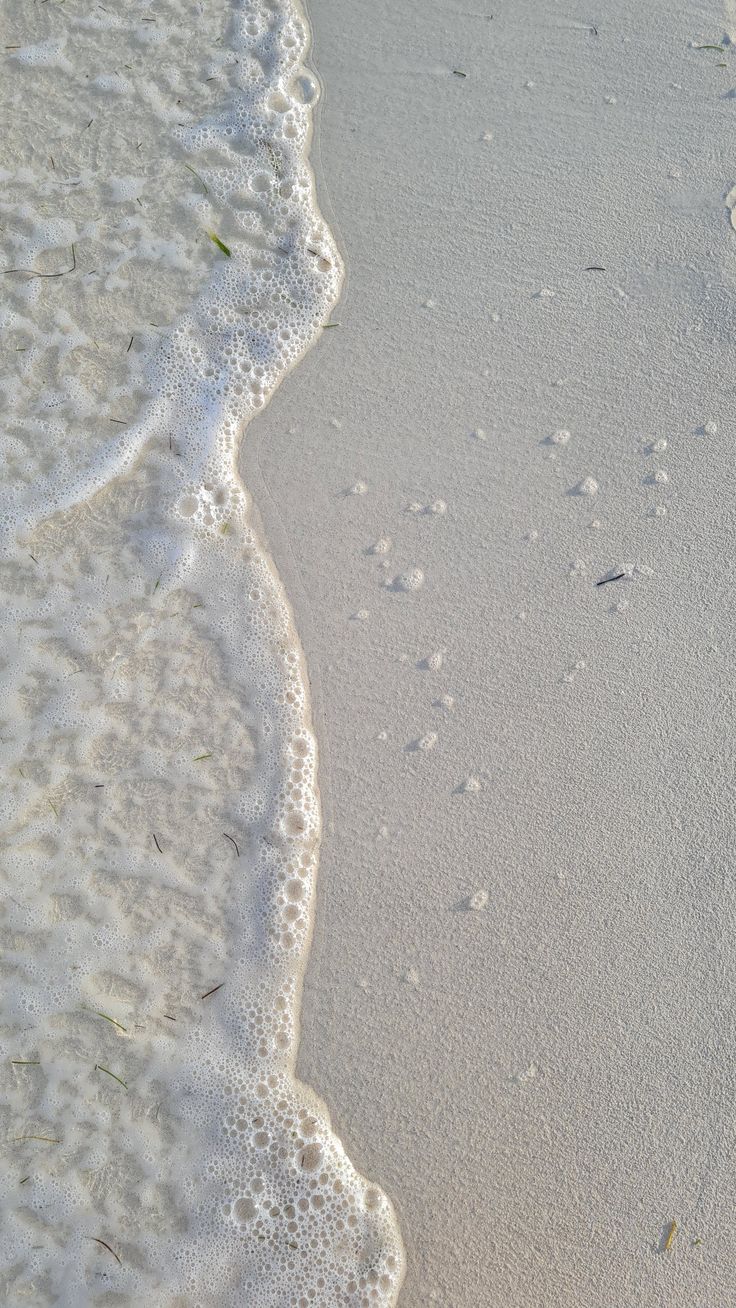 footprints in the sand and water at the beach