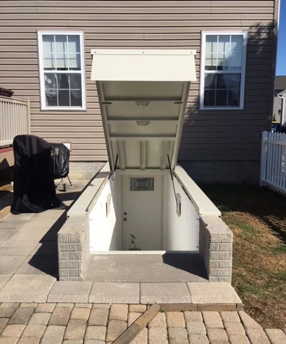 an open door on the side of a house with brick pavers in front of it