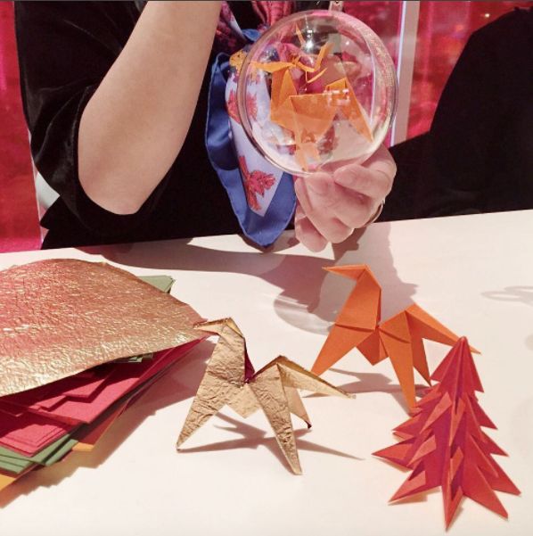 someone is holding up some origami stars to make them look like christmas trees