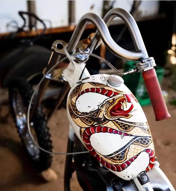 a close up of a motorcycle with a snake painted on it