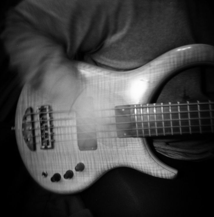 a person is playing an electric guitar in black and white photo with blurry background