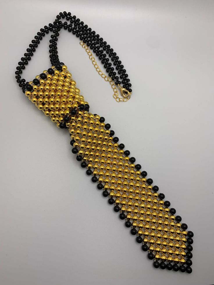 Black and Gold Pearl neck tie High quality gold pearls! Black Jewelry With Ties For Gifts, Black Ties Jewelry For Gift, Gift Black Jewelry With Ties, Classic Jewelry With Ties For Parties, Luxury Gold Tie For Formal Occasions, Elegant Gold Ties For Business, Elegant Black Neckwear For Gift, Elegant Gold Ties For Party, Elegant Adjustable Gold Tie