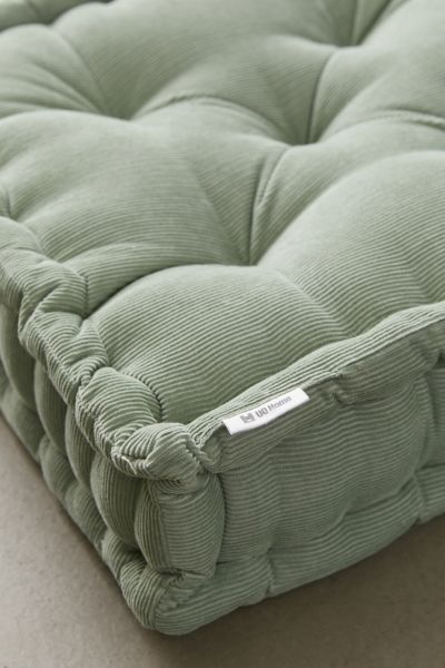 a close up view of a green mattress on the floor with no sheets or pillows