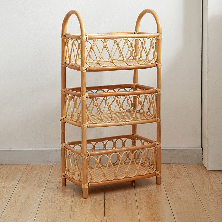 a bamboo shelf with three baskets sitting on it's sides, against a white wall