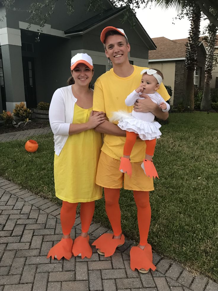 a man and woman are dressed up in costumes for halloween, while holding a baby