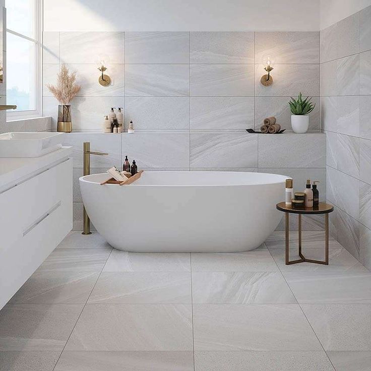 a white bath tub sitting in a bathroom next to a window