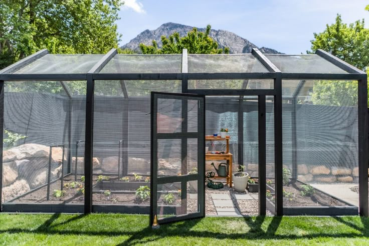 a small greenhouse in the middle of some grass