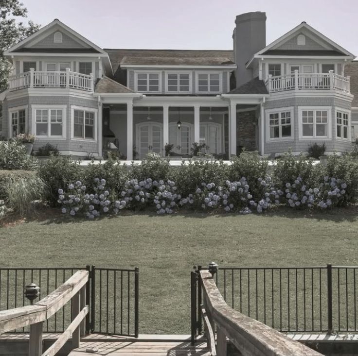 a large white house sitting on top of a lush green field