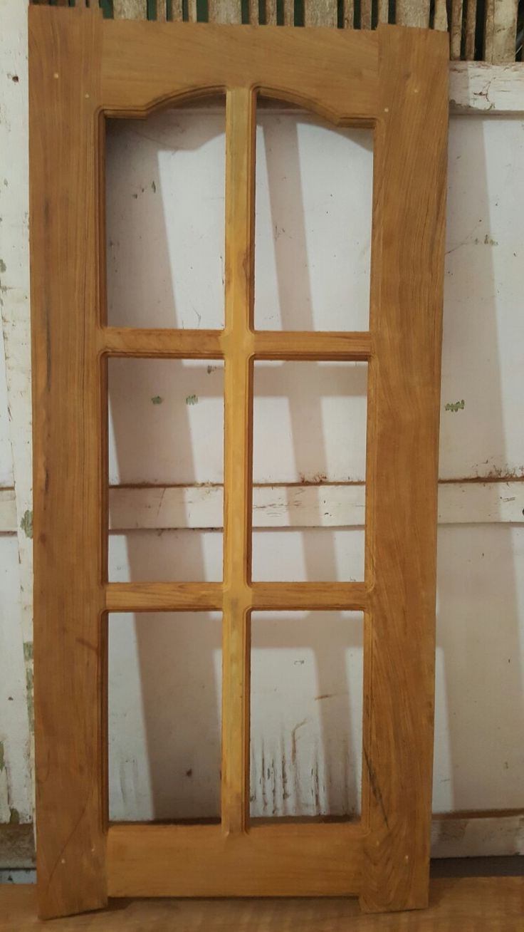 a wooden window frame sitting on top of a hard wood floor next to a wall