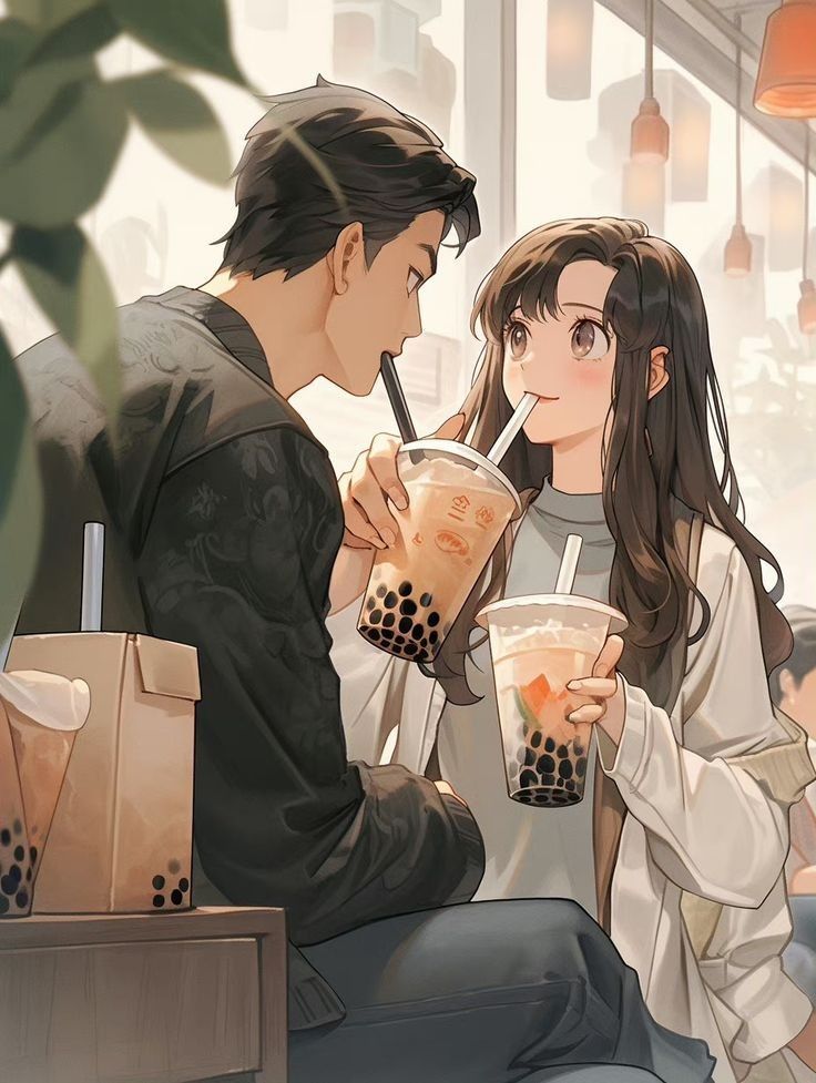 a man and woman sitting next to each other holding drinks