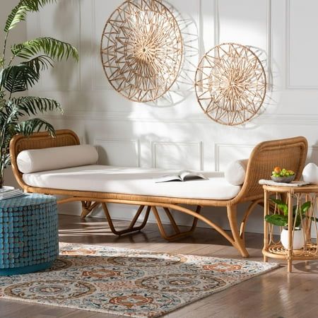 a living room with wicker furniture and rugs on the hardwood floor, along with two circular wall sculptures