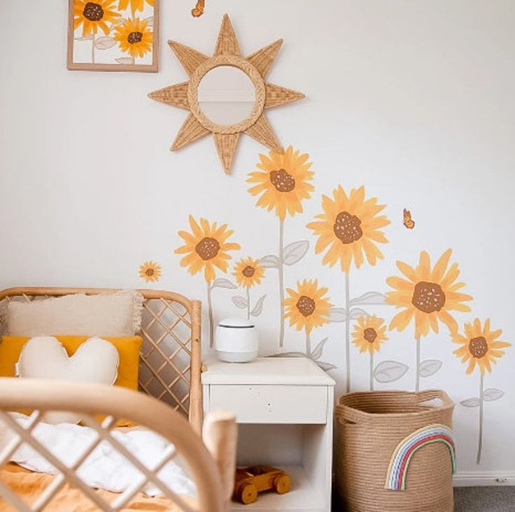 a baby's room with sunflowers painted on the wall